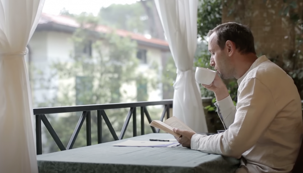 man reading while drinking a cup of espresso coffee